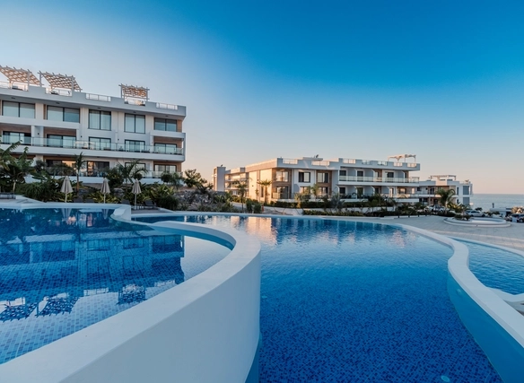 Modern Caesar Cliff apartment complex with infinity pools and sea view under a clear sky