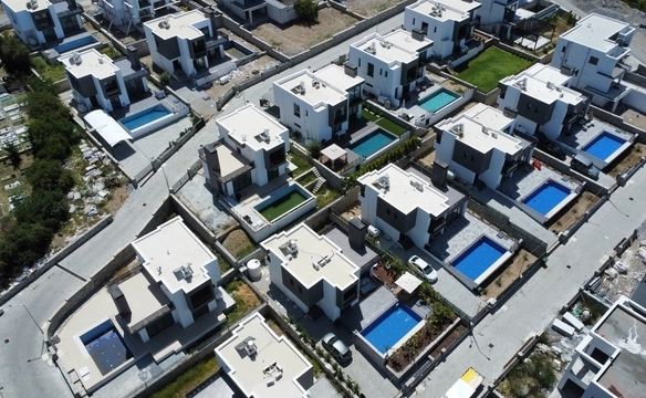 Images showcasing a modern 4-bedroom villa in Karmi, Kyrenia, including exterior architecture, stylish bedrooms, walk-in closet, and panoramic sea views from a hillside location.