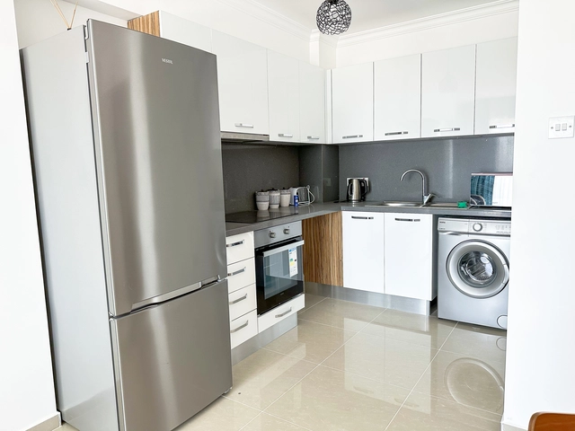 Modern 2-bedroom apartment in Long Beach, North Cyprus with sea views, fully furnished interiors, fitted kitchen, bright living room, two cozy bedrooms, and a private balcony overlooking the Mediterranean.