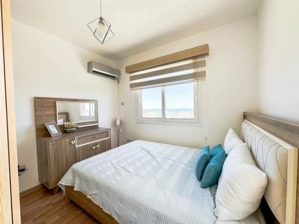 Modern 2-bedroom apartment in Long Beach, North Cyprus with sea views, fully furnished interiors, fitted kitchen, bright living room, two cozy bedrooms, and a private balcony overlooking the Mediterranean.