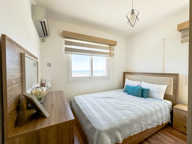 Modern 2-bedroom apartment in Long Beach, North Cyprus with sea views, fully furnished interiors, fitted kitchen, bright living room, two cozy bedrooms, and a private balcony overlooking the Mediterranean.