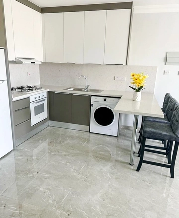 Fully furnished 1-bedroom apartment in Park Residence Long Beach with modern open-plan kitchen, bright living room, spacious balcony, and ready-to-move-in condition in North Cyprus