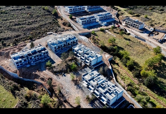 Modern 1-bedroom garden apartment in Spectra Project Lapta featuring stylish interior design, open-plan kitchen, spacious living area, and scenic mountain and pool views in North Cyprus.