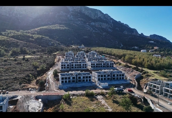 Modern 1-bedroom garden apartment in Spectra Project Lapta featuring stylish interior design, open-plan kitchen, spacious living area, and scenic mountain and pool views in North Cyprus.